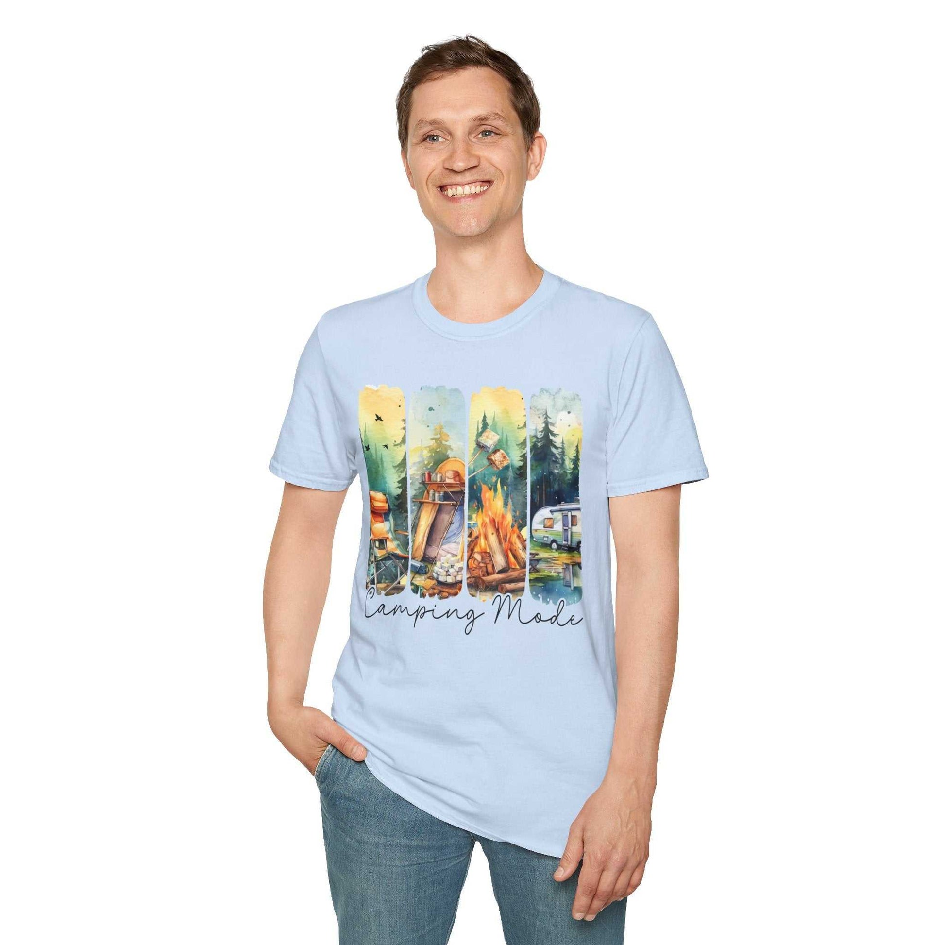 Smiling man wearing light blue unisex Camping Adventure T-shirt with colorful outdoor camping graphic and "Camping Mode" text, paired with blue jeans.