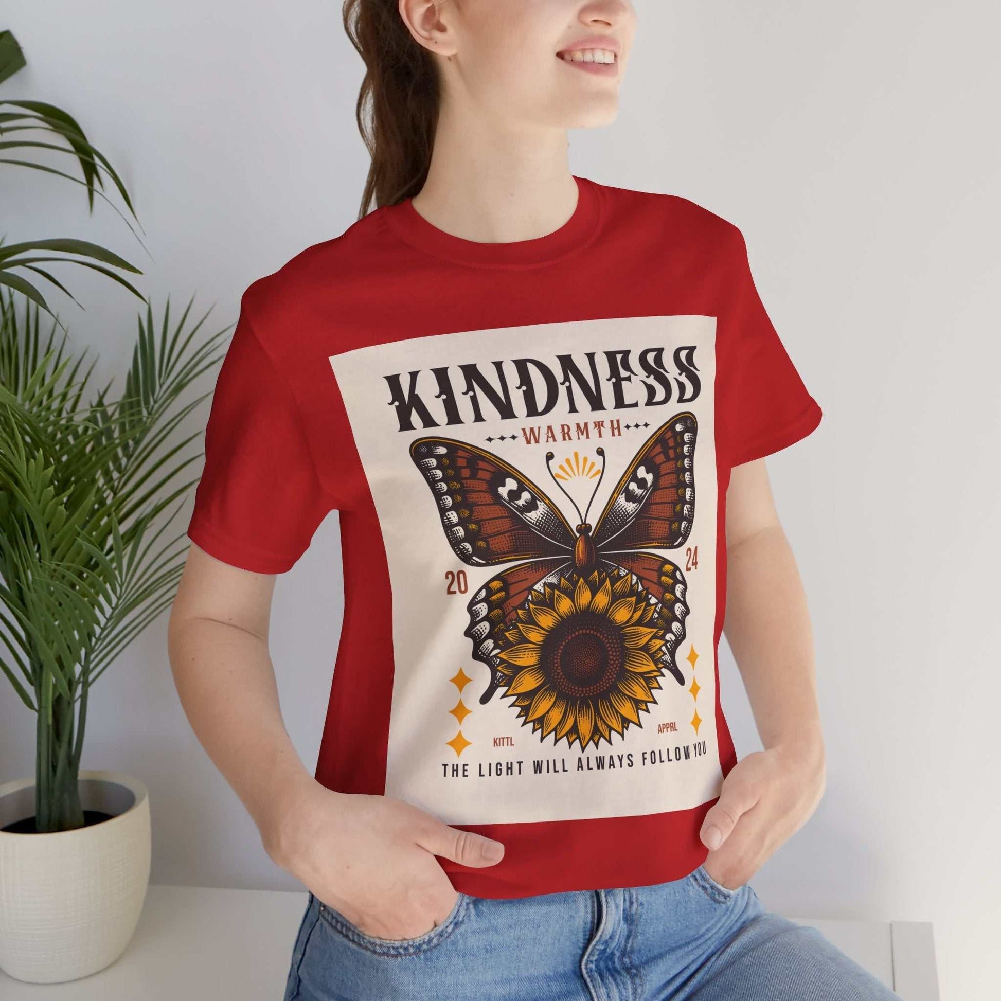 Woman wearing red Kindness Butterfly Tee with butterfly and sunflower graphic and positive message