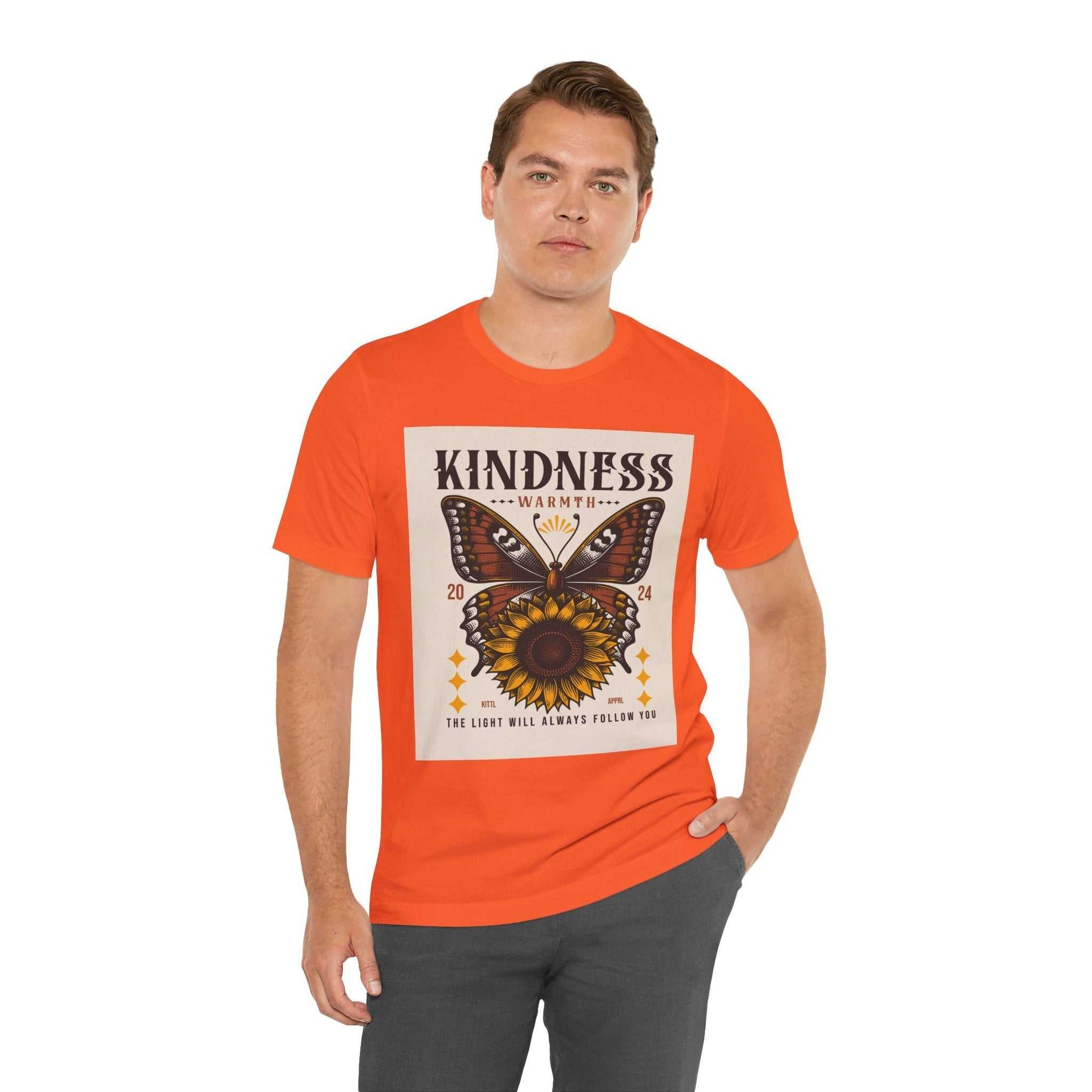Man wearing orange Kindness Butterfly Tee with butterfly and sunflower graphic and kindness message