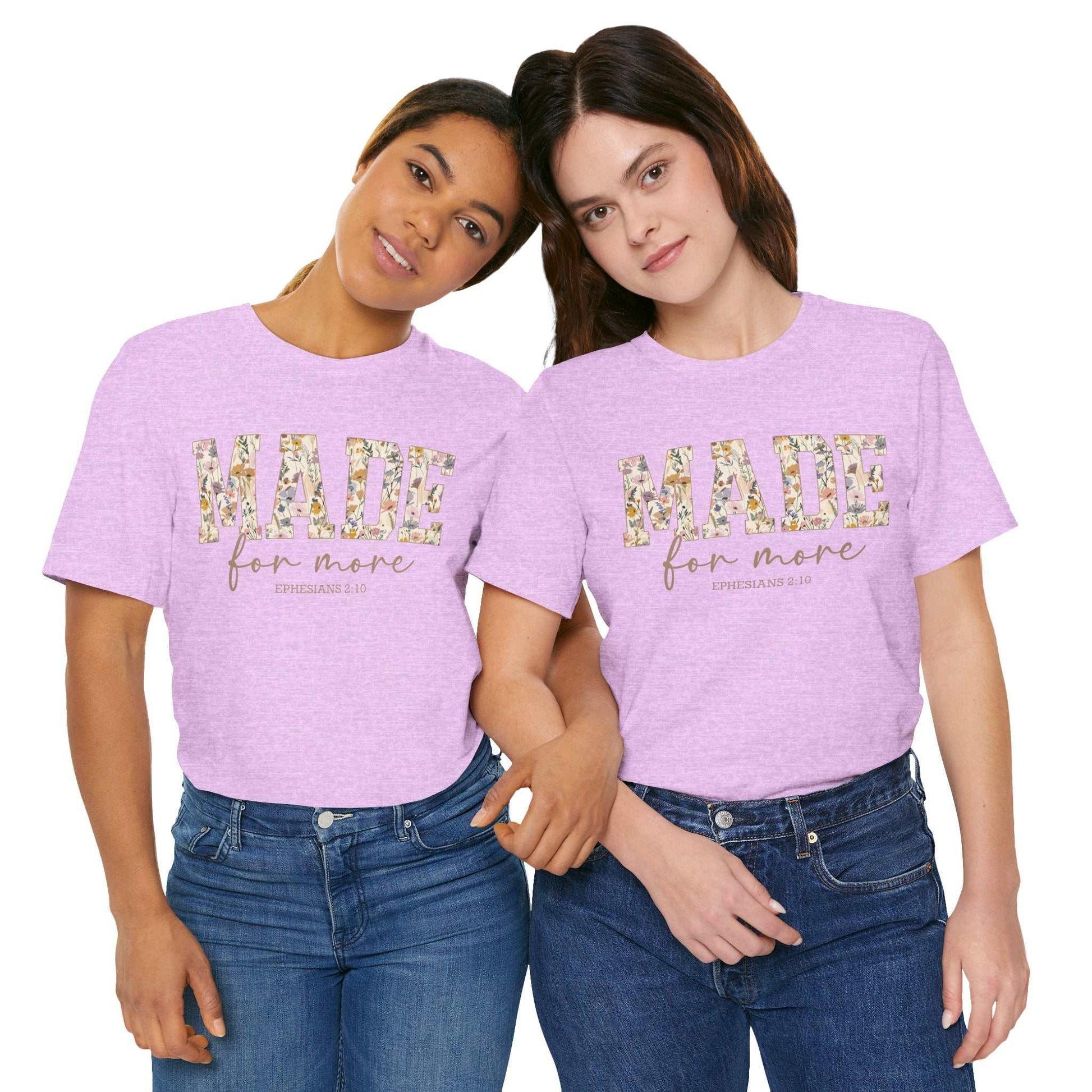 Two women wearing light purple Made for More Tee shirts with floral text design on front standing close together