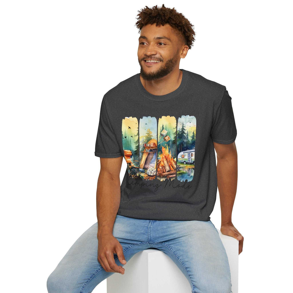 Man wearing a dark gray Camping Adventure Unisex T-Shirt with colorful camping-themed graphics sitting on a white cube.