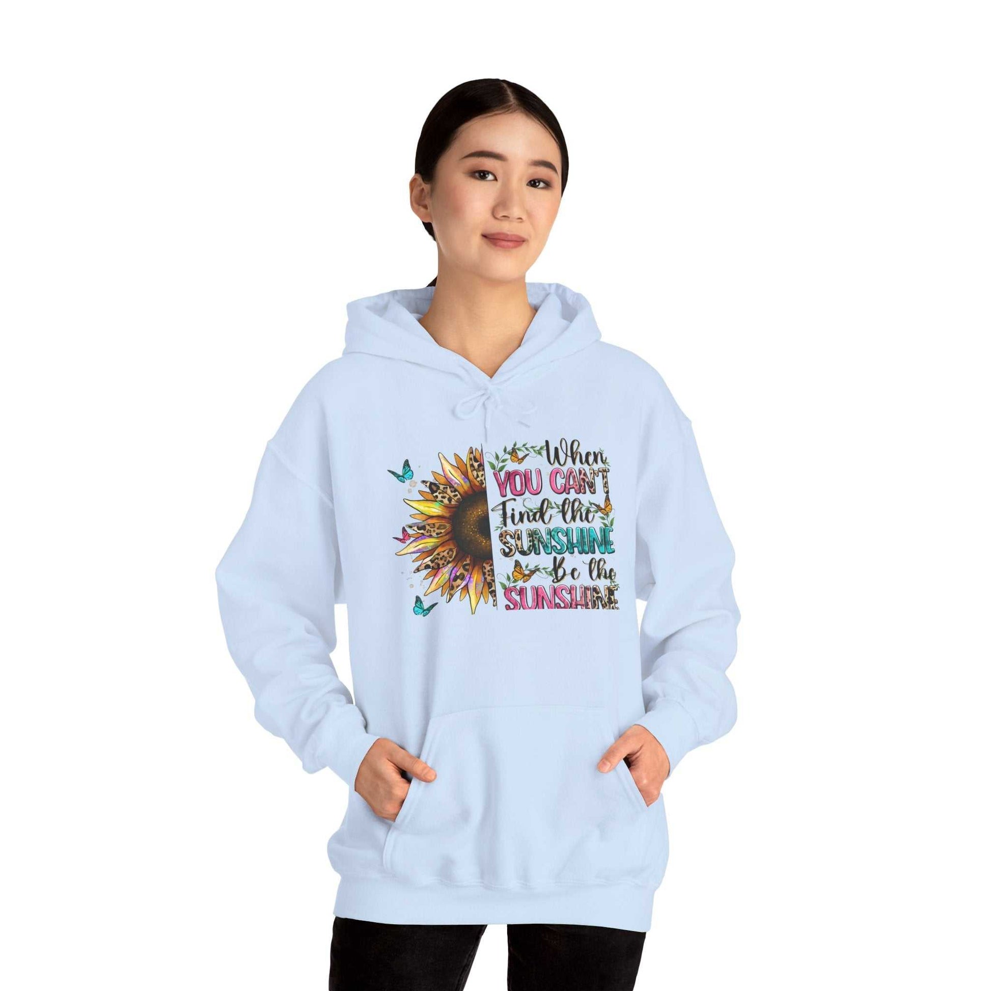 Woman wearing light blue sunflower quote hoodie with inspirational message and kangaroo pocket