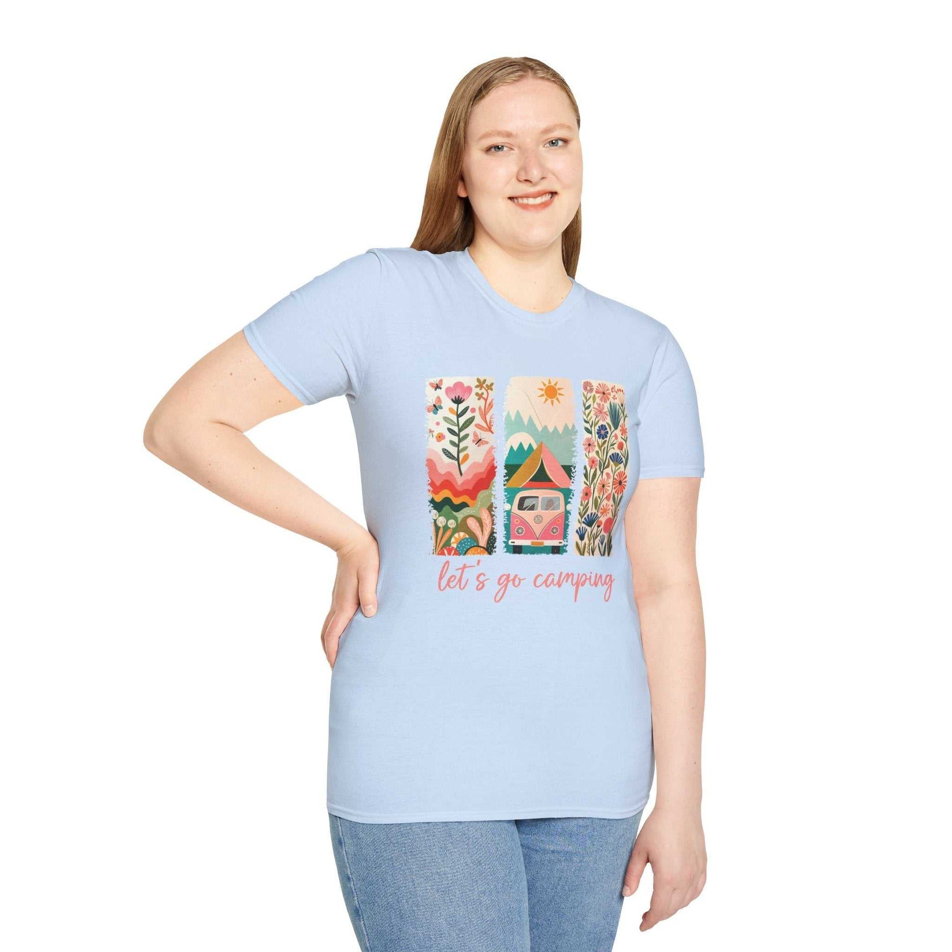Woman wearing light blue unisex Camping Adventure T-shirt with colorful nature and camper design and "let's go camping" text.